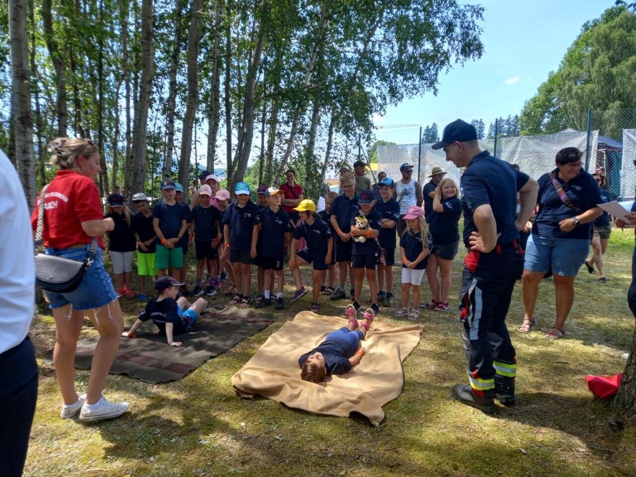 Teamspiel mit der Rettungsdecke bei der Kinderflamme Orange